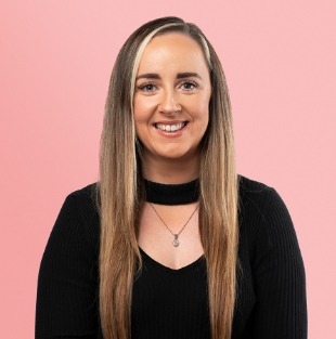 Woman with long dark blonde hair wearing black long sleeve top